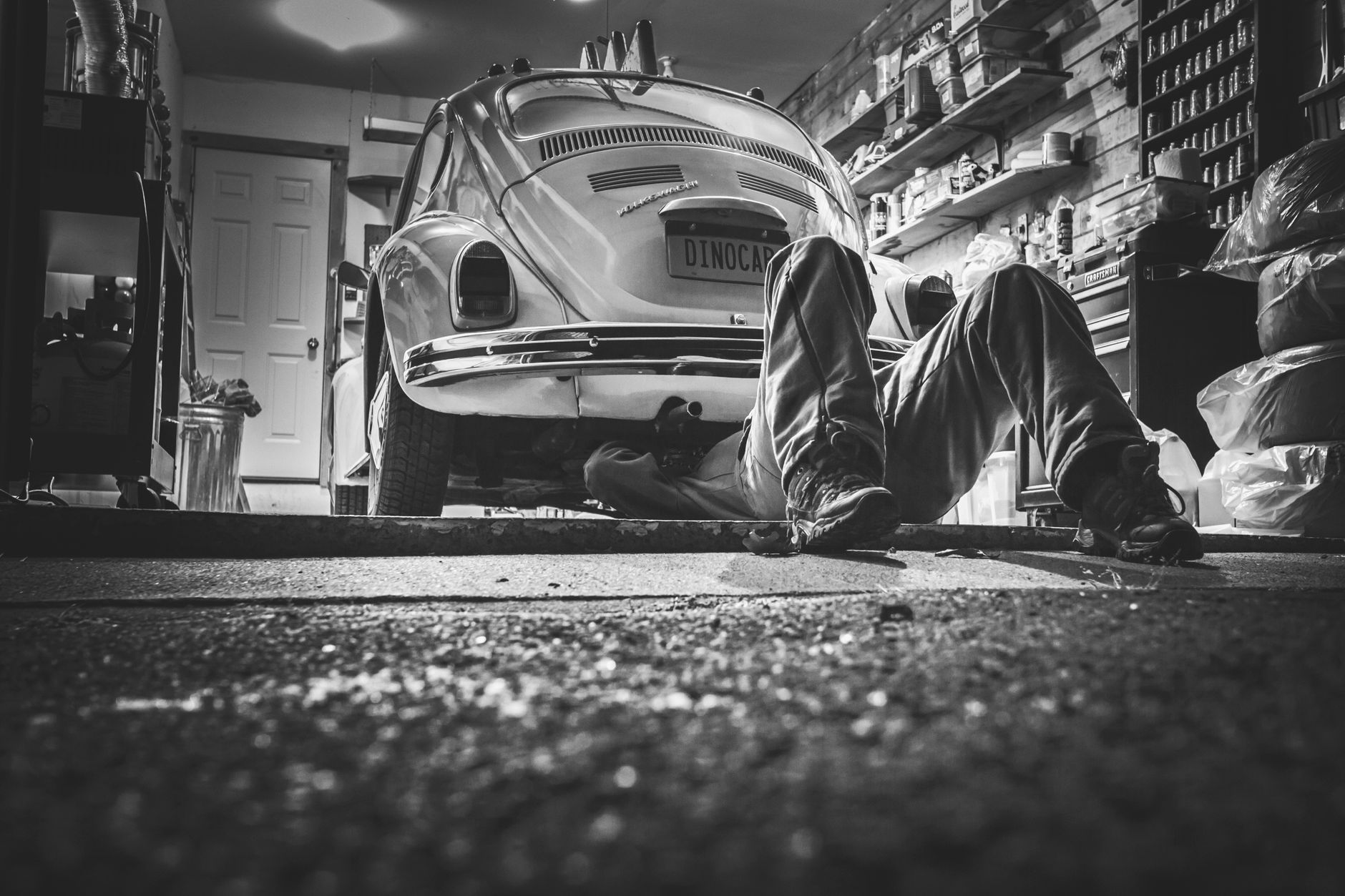 Mechanic working beneath a vintage car